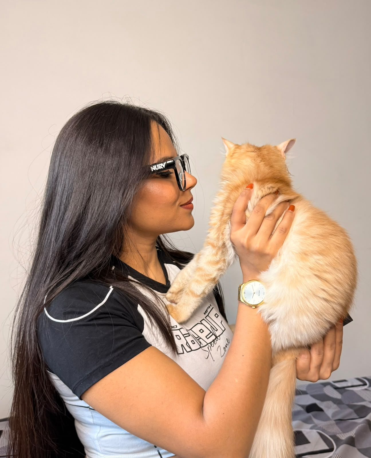 A pet parent smiling with her fluffy orange cat